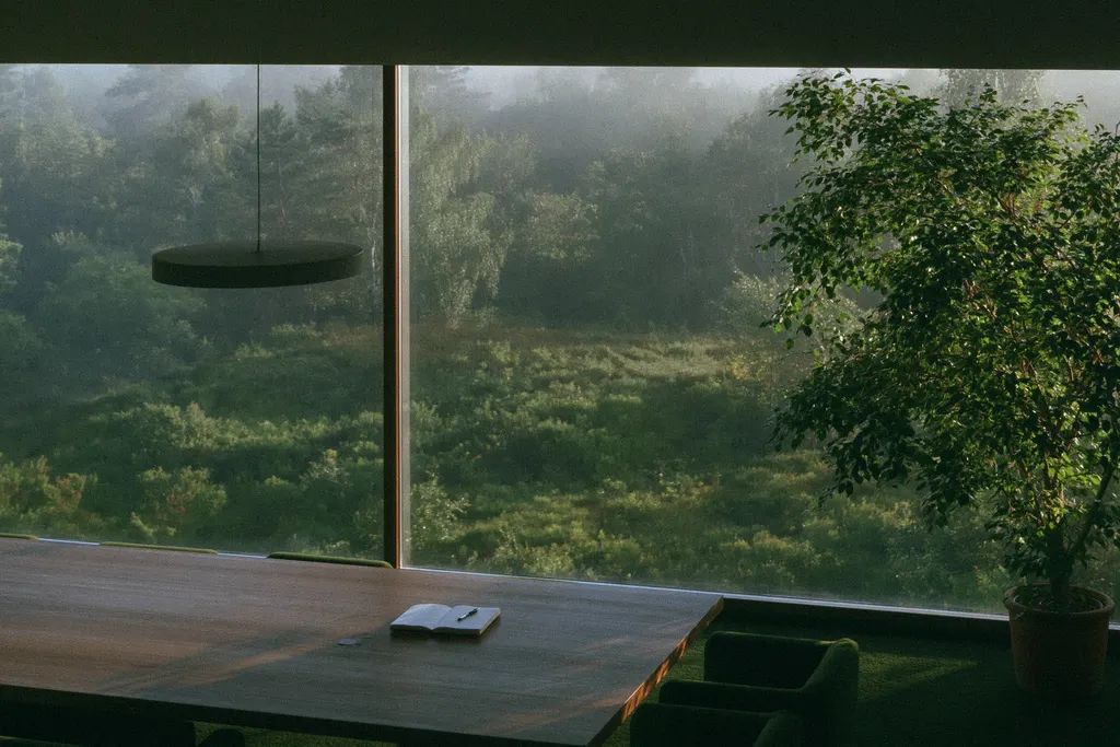 Besprechungstisch an einer Glasfront mit Blick auf nebligen Wald